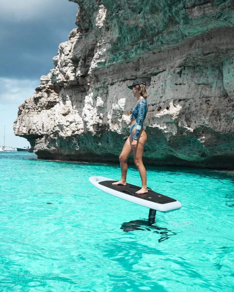 Rider gliding on a Lift eFoil board over clear turquoise water