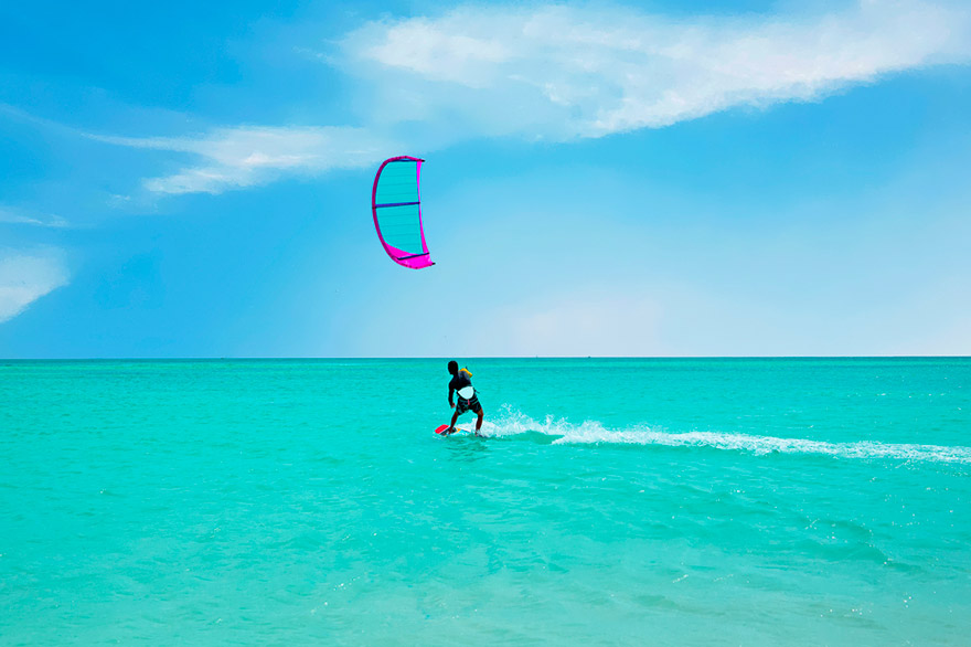 Kitesurfer riding across bright turquoise Bermuda water